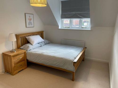 um pequeno quarto com uma cama e uma janela em New - Beautiful Countryside Home em Streatley