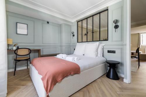 een slaapkamer met een groot bed en een bureau bij Poetic Stay - Louvre in Parijs