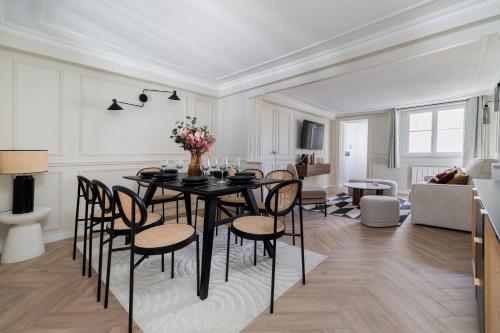 een eetkamer en een woonkamer met een tafel en stoelen bij Poetic Stay - Louvre in Parijs