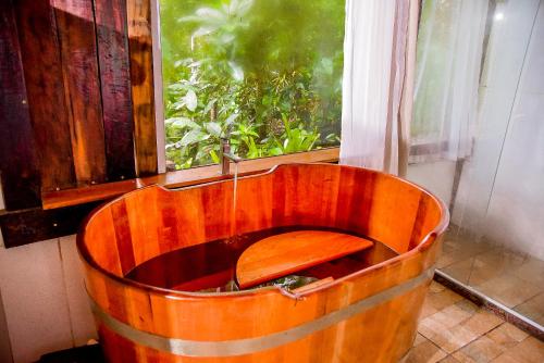 a wooden tub sitting in front of a window at Pipas de Araras - Cabernet in Petrópolis