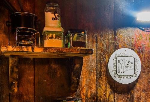 a wooden table with a bottle and glasses on it at Pipas de Araras - Cabernet in Petrópolis