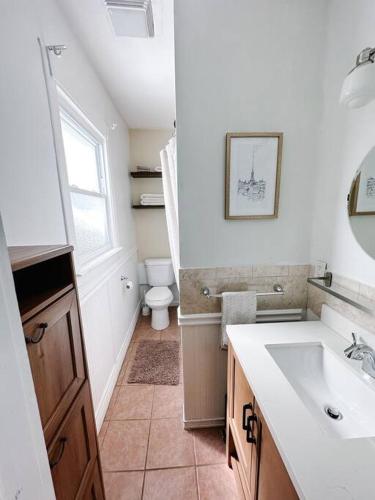 a white bathroom with a sink and a toilet at Historic peaceful apartment in New Haven