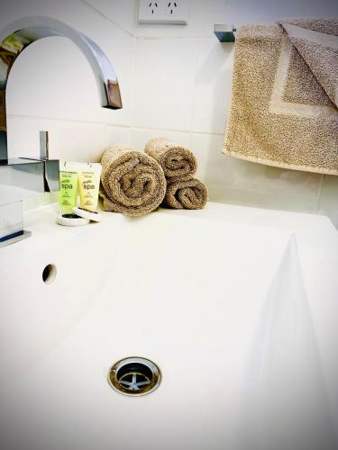 a sink with rolled towels on top of it at Auto Lodge Motor Inn in Seymour