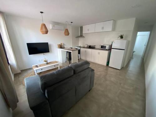 sala de estar con sofá y cocina en Apartamento céntrico en Paysandú