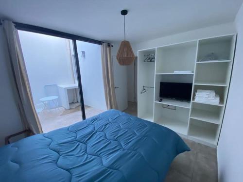 ein Schlafzimmer mit einem blauen Bett und einem großen Fenster in der Unterkunft Apartamento céntrico in Paysandú