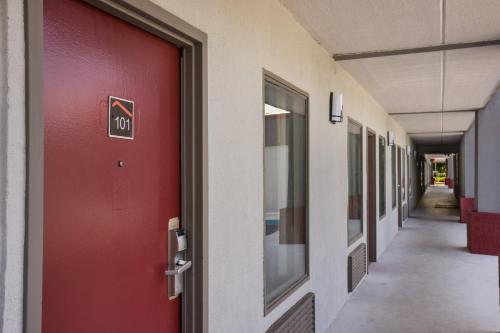 a red door in a hallway of a building at Red Roof Inn & Suites Statesboro - University in Statesboro