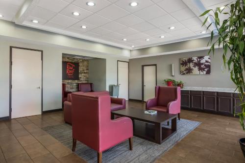 a waiting room with chairs and a table at Red Roof Inn & Suites Statesboro - University in Statesboro