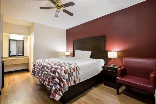 a hotel room with a bed and a chair at Red Roof Inn & Suites Statesboro - University in Statesboro