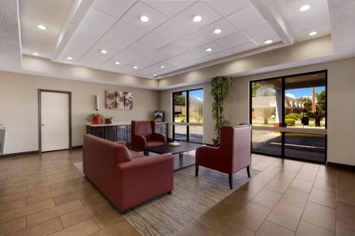a waiting room with chairs and a table and windows at Red Roof Inn & Suites Statesboro - University in Statesboro