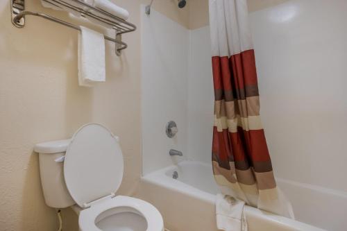 a bathroom with a toilet and a shower curtain at Red Roof Inn & Suites Statesboro - University in Statesboro