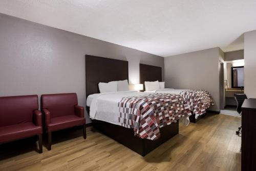 a hotel room with a bed and a chair at Red Roof Inn & Suites Statesboro - University in Statesboro