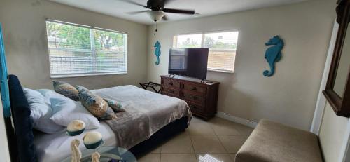 a bedroom with a bed and a flat screen tv at Prime Location-Equipped House W Pool & Patios, Near the Beaches, Ideal for Small Families, Coastal Haven in Fort Lauderdale