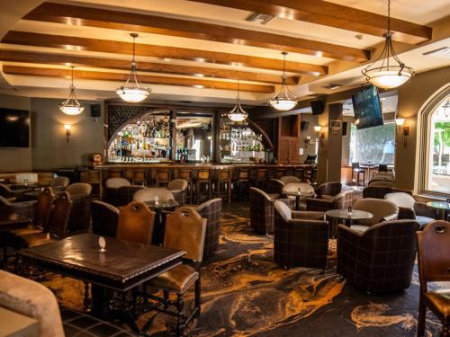 a restaurant with tables and chairs and a bar at Hotel Araiza Mexicali in Mexicali