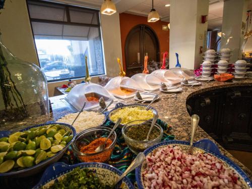 a kitchen counter with many bowls of food on it at Hotel Araiza Mexicali in Mexicali