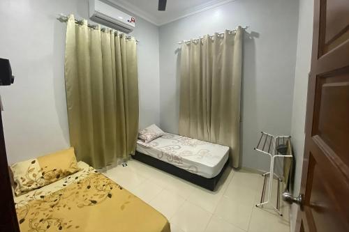 Cette petite chambre comprend deux lits et une douche. dans l'établissement Syikin Homestay - Private Pool, à Bedung