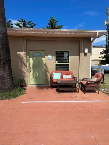 una casa con dos sillas y una puerta verde en Seaside bungalow, en Daytona Beach