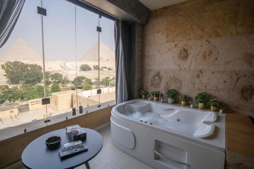 ein Badezimmer mit Badewanne und Blick auf die Pyramiden in der Unterkunft Great Pyramid Inn in Kairo