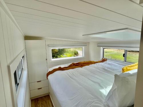 a bedroom in a tiny house with a bed and a window at freed.Omspace in Broken Head