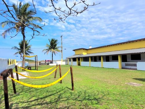 a yard with a hammock in front of a building at Itamiaru Beach Apartamentos in Ilha Comprida