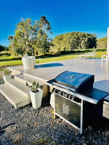 a grill on top of a wooden deck with a grill at freed.Omspace in Broken Head