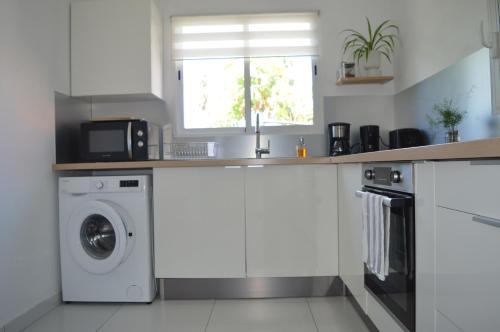 una cucina con lavatrice e finestra di Maison La Caféière a Saint-Claude