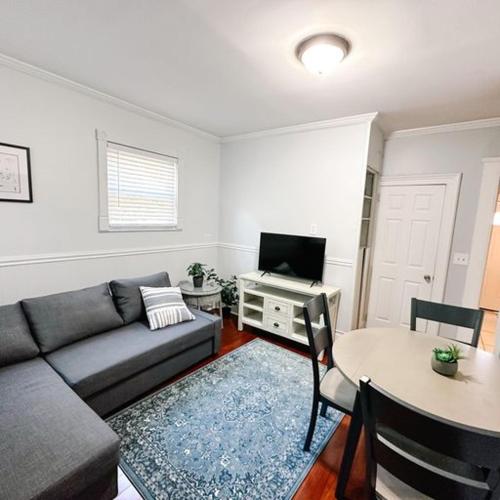 a living room with a couch and a table at Historic peaceful apartment in New Haven