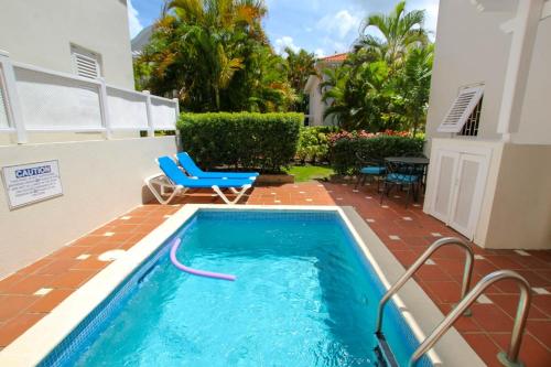 a small swimming pool with a blue chair and a house at Turtle View 2 by BSL Rentals in Saint James