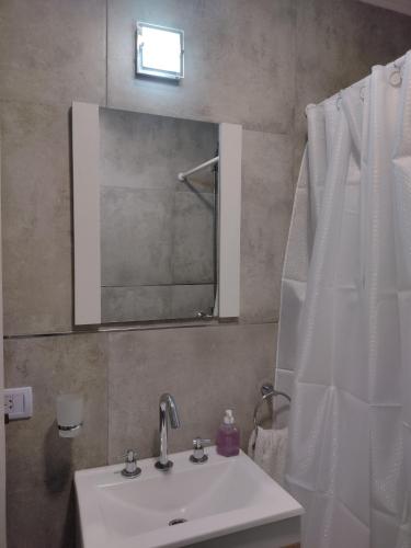 ein Bad mit einem Waschbecken und einem Spiegel in der Unterkunft Depto Saladillo in Saladillo