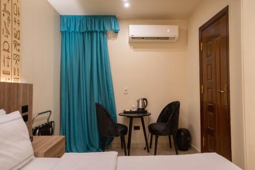 a room with a bed and a table with chairs at Great Pyramid Inn in Cairo