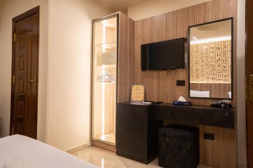 a hotel room with a desk and a mirror at Great Pyramid Inn in Cairo