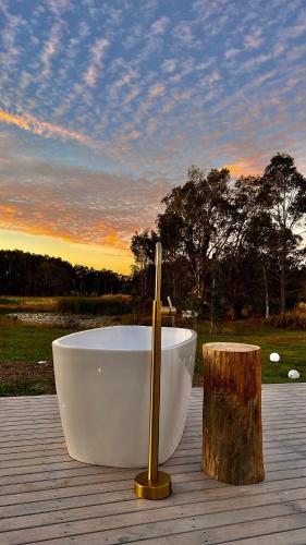 a bath tub sitting on top of a wooden deck at freed.Omspace in Broken Head