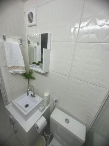 ein weißes Badezimmer mit Toilette und Waschbecken in der Unterkunft Kitnet 6 pessoas na Barra in Salvador