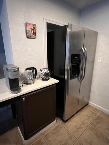 a kitchen with a stainless steel refrigerator next to a counter at Beautiful Bungalow in Orlando