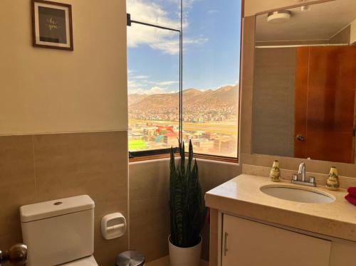 ein Bad mit einem WC und einem Waschbecken mit einem Fenster in der Unterkunft hermoso departamento en zona residencial de cusco in Cusco