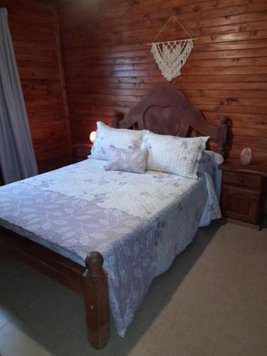 ein Schlafzimmer mit einem Bett mit einer Holzwand in der Unterkunft Cabañas Edna in Tinogasta