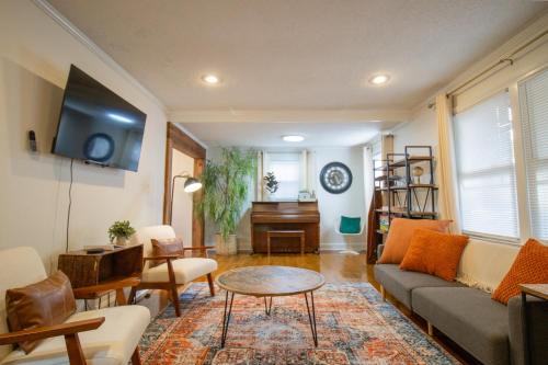 a living room with a couch and a table and a piano at Cozy Mauldin Hill by Brick and Home in Simpsonville