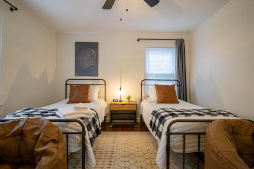 two twin beds in a room with a window at Industrial Chic Getaway Simpsonville - Family Home in Simpsonville