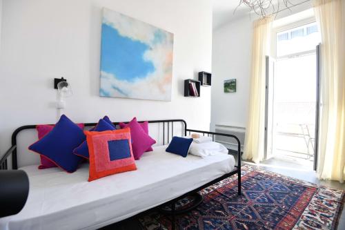 une chambre avec un lit avec des oreillers colorés dessus dans l'établissement Appart 1 ch clim - 50m des plages et des Calanques, à Marseille