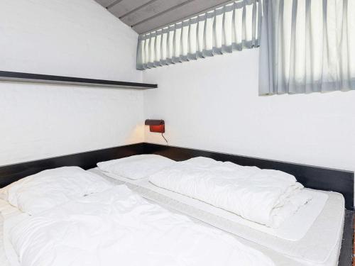 Cama blanca en habitación con ventana en Apartment Brovst XII, en Brovst