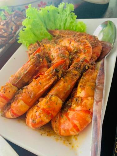 a plate of food with shrimp and lettuce on it at Bolo Hills Beach Club And Residence in Alaminos