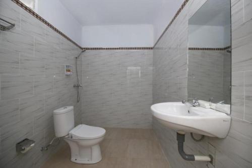 ein weißes Bad mit einem WC und einem Waschbecken in der Unterkunft Kanten Sweet in Toyapakeh