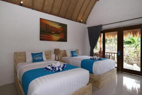 1 dormitorio con 2 camas en azul y blanco en Kanten Sweet, en Toyapakeh
