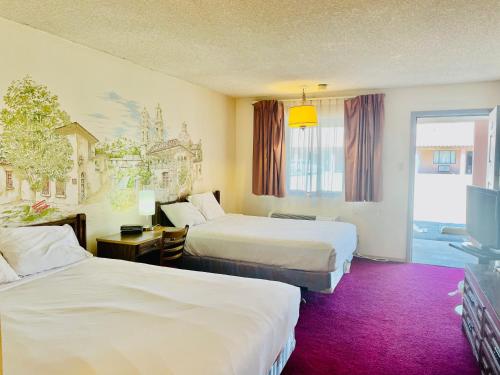 ein Hotelzimmer mit 2 Betten und einem TV in der Unterkunft San Miguel Inn in Socorro