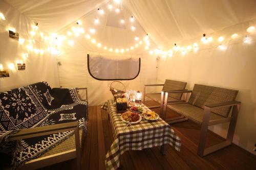 a tent with a table with food and lights at Dongnae Hound Hotel Sajik Minam Station in Busan