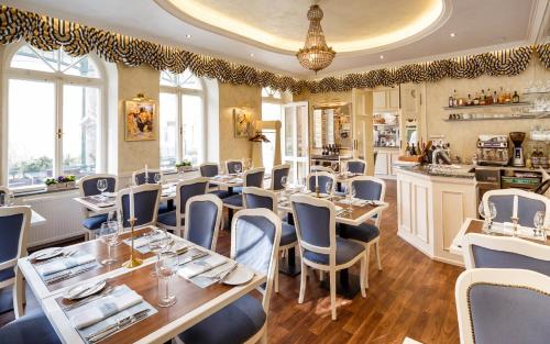 restauracja ze stołami i krzesłami w pokoju w obiekcie Villa Basileia Riverside w Karlowych Warach
