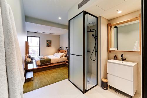 a bathroom with a shower and a bedroom at Central Club Hotel - North Melbourne in Melbourne