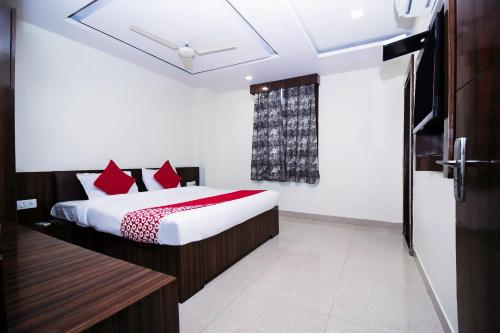 a bedroom with a bed with red pillows at OYO Flagship Hotel Galaxy Palace in Ajmer