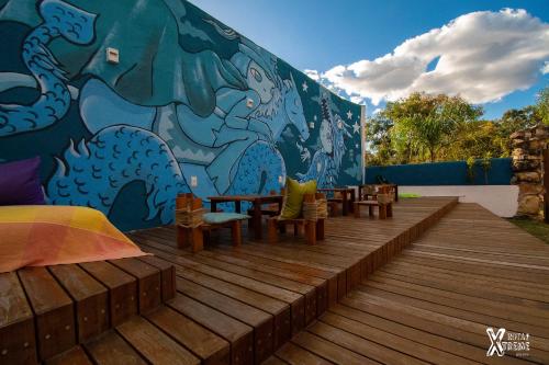 a mural on the side of a building with a deck at Espaço Shanti - Chalés in Sao Jorge