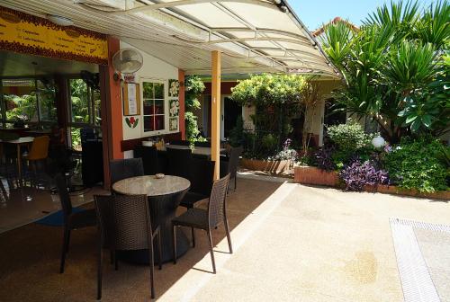 een patio met een tafel, stoelen en planten bij Udon Thai House Resort & Hotel in Udon Thani