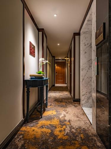 a corridor of a hotel with a table in a hallway at GRAND HOTEL du LAC Hanoi in Hanoi